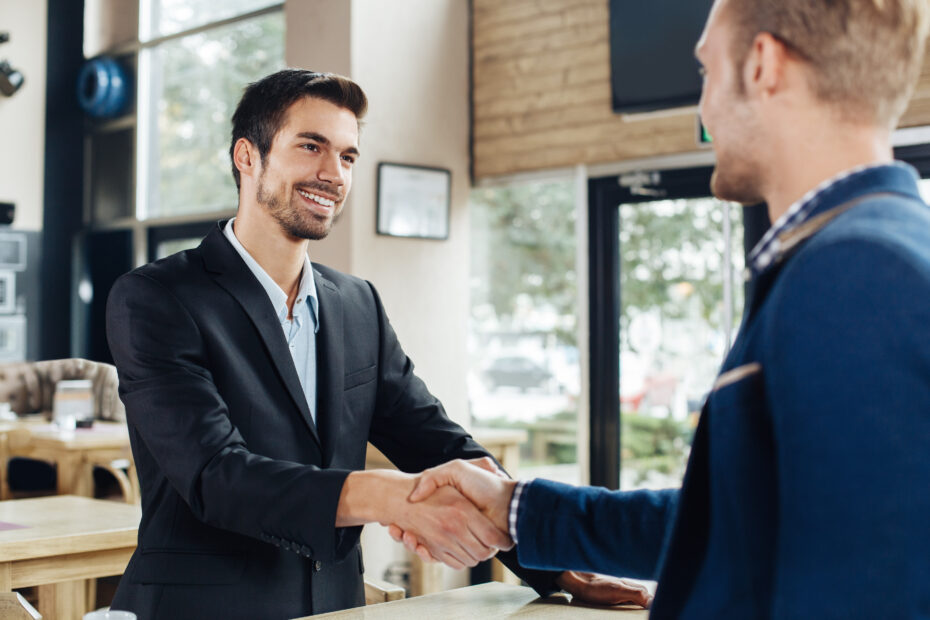 Dois empresários apertando as mãos em um café